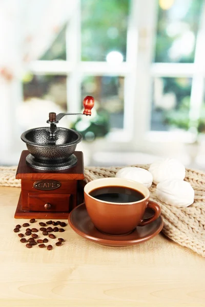 Taza de café con bufanda y molino de café en la mesa en la habitación — Foto de Stock