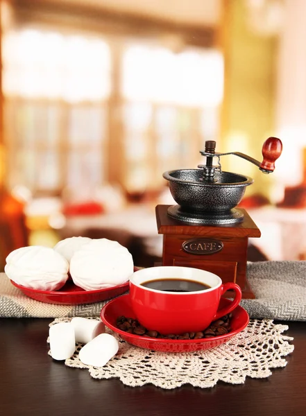 Taza de café con bufanda y molino de café en la mesa en la habitación —  Fotos de Stock