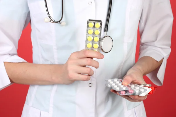 Primer plano de las píldoras de la mano del médico femenino, sobre fondo de color — Foto de Stock