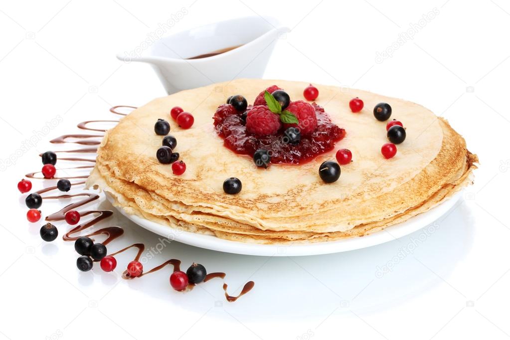 Delicious pancakes with berries and jam on plate isolated on white