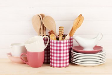 Cups, bowls nd other utensils in metal containers isolated on light background