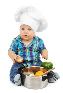 şef şapkasını pan ve sebzeler üzerinde beyaz izole, küçük çocuk