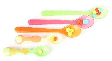 plastik kaşık ile üzerine beyaz izole renkli hapları