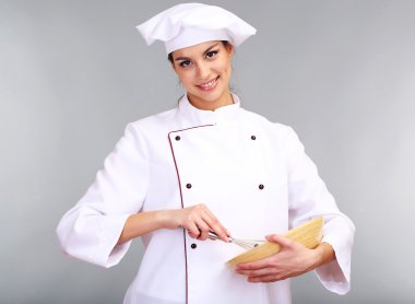 genç kadın Şefle wisk gri arka plan üzerinde portresi