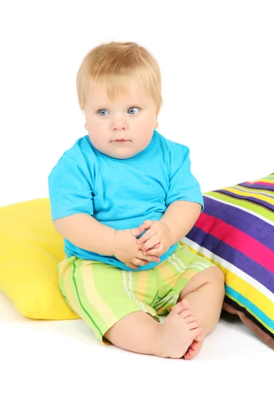 Маленький хлопчик і кольорові подушки, ізольовані на білому — стокове фото