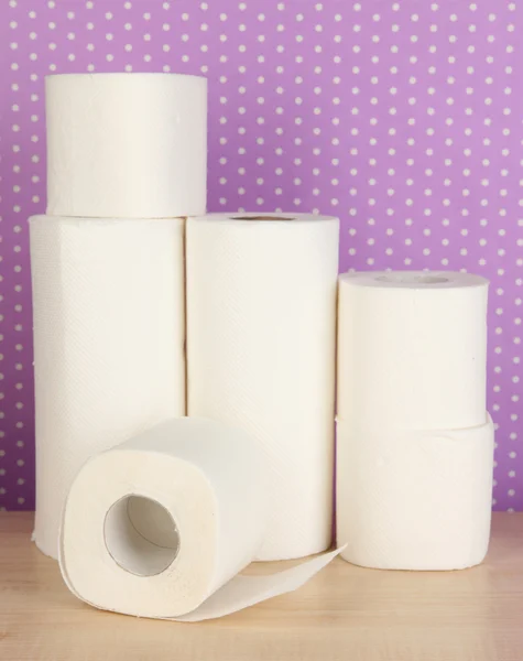 Rolls of toilet paper on purple with dots background — Stock Photo, Image