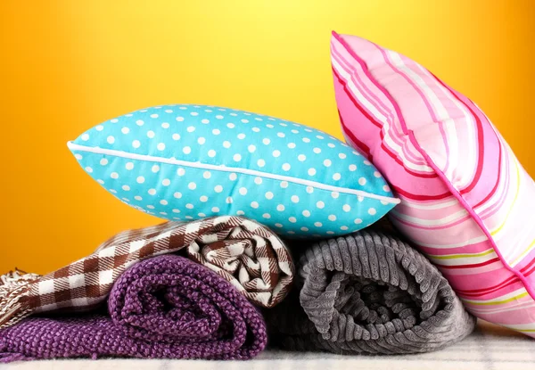 Plaids and color pillows on yellow background — Stock Photo, Image