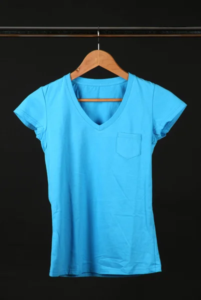 T-shirt on wooden hanger, isolated on black — Stock Photo, Image