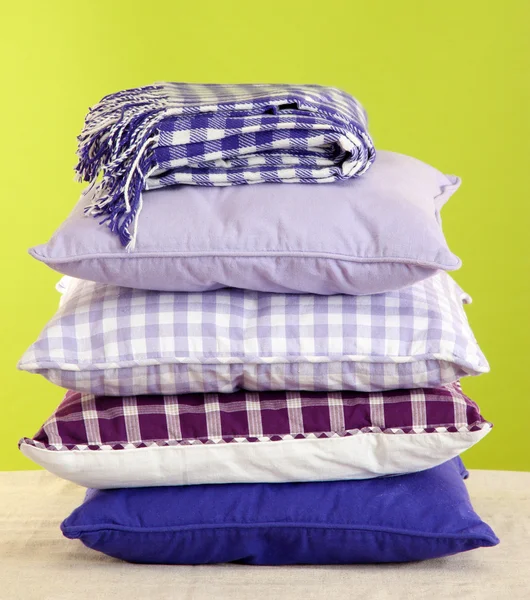 Colina almohadas de colores y cuadros sobre fondo verde —  Fotos de Stock