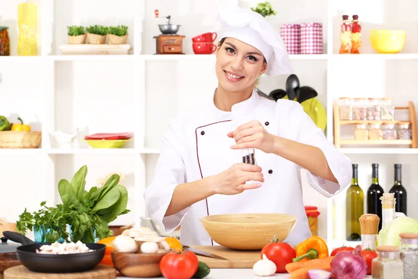 Young woman chef cooking in kitchen — Stock Photo, Image