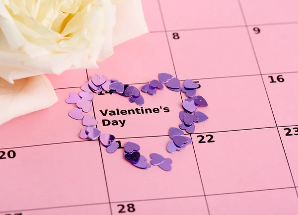 Notas sobre el calendario (día de San Valentín) y rosa, primer plano — Foto de Stock