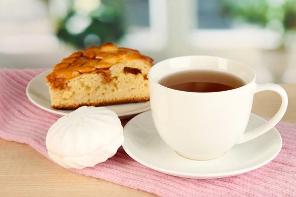 Cup of tea with scarf on table in room — Stock Photo, Image