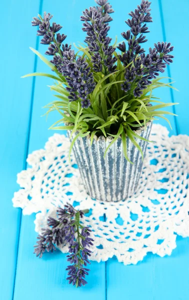 Декоративная лаванда в вазе на синем деревянном столе крупным планом — стоковое фото