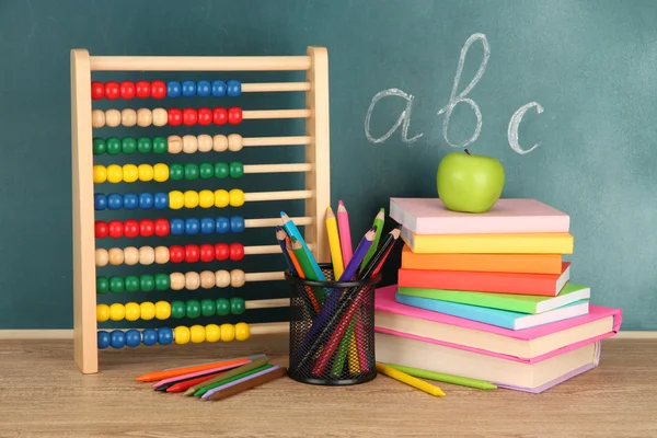 Toy abacus, books and pencils on table, on school desk background — Stock Photo, Image