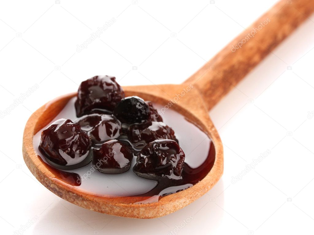 tasty berry jam in wooden spoon, isolated on white