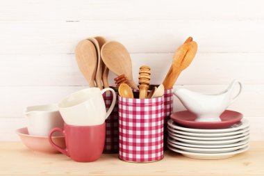 Cups, bowls nd other utensils in metal containers isolated on light background
