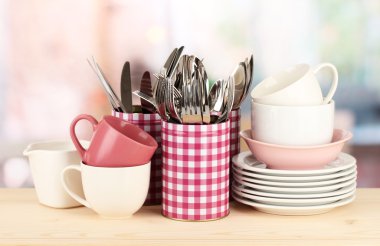 Cups, bowls nd other utensils in metal containers isolated on light background