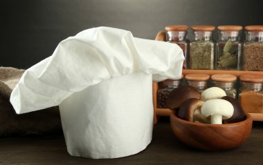 Şef'in şapkası ve kitchenwear tabloda gri arka plan üzerinde kompozisyonu