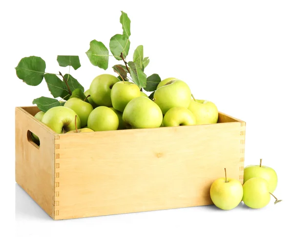 Šťavnatá jablka se zelenými listy v dřevěné bedně, izolované na bílém — Stock fotografie
