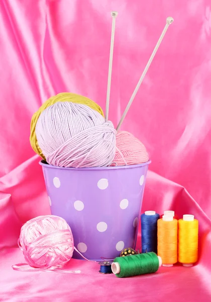 Color bucket with multicolor balls of tread on color fabric background — Stock Photo, Image