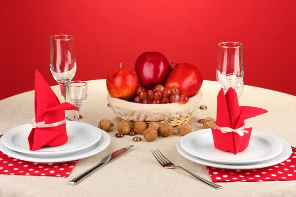 Table setting in red tones on color background — Stock Photo, Image