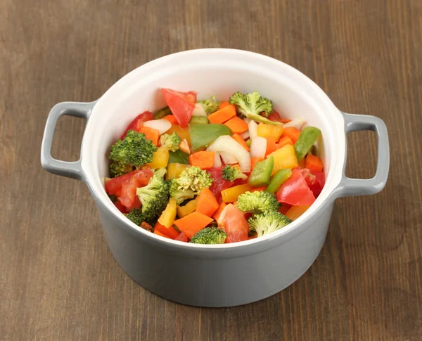 Ragoût de légumes en pot gris sur fond bois — Photo