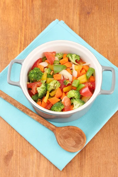 Guisado de legumes no pote cinza no guardanapo de cor no fundo de madeira — Fotografia de Stock