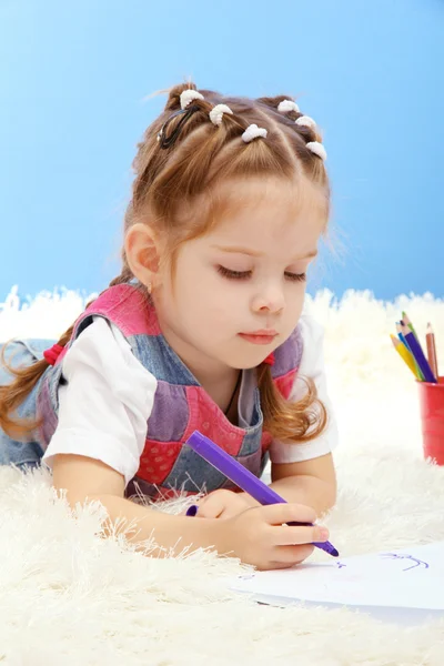 Schattig klein meisje spelen met multicolor potloden, op blauwe achtergrond — Stockfoto