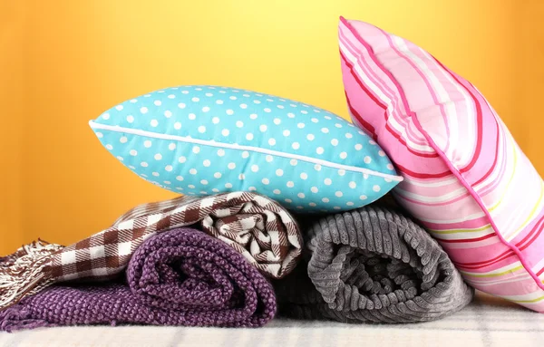 Plaids and color pillows on yellow background — Stock Photo, Image