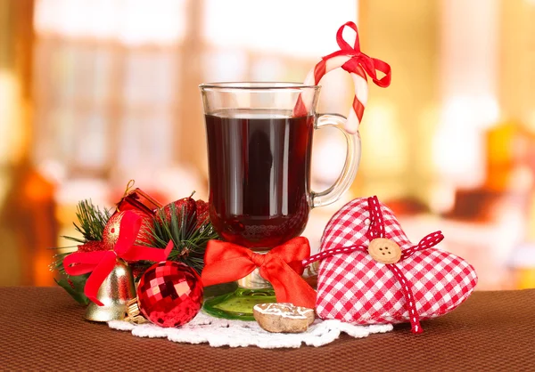 Hot tasty drink with christmas candy and other decorations on bright background — Stock Photo, Image