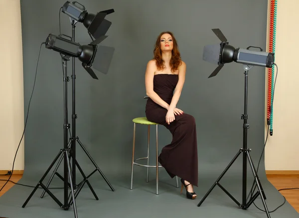 Beautiful professional female model resting between shots in photography studio shoot set-up — Stock Photo, Image