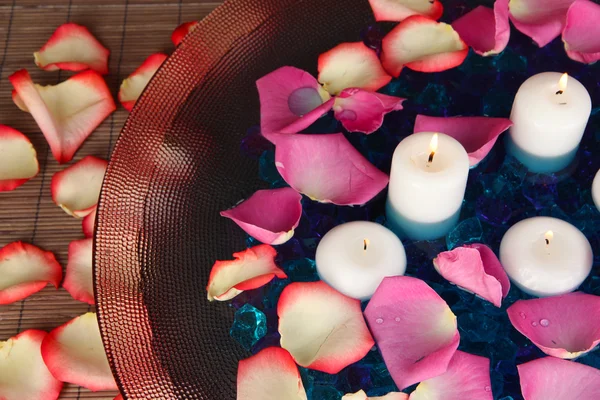 Petali di rosa e candele in acqua in vaso primo piano — Foto Stock