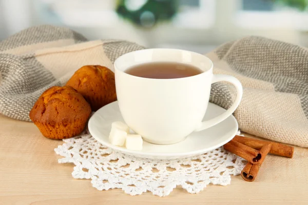 Tasse de thé avec écharpe sur la table dans la chambre — Photo