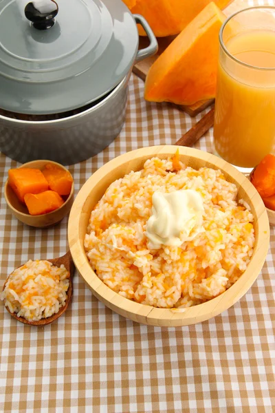 Prove mingau de arroz com abóbora e copo de suco no fundo de toalha de mesa — Fotografia de Stock