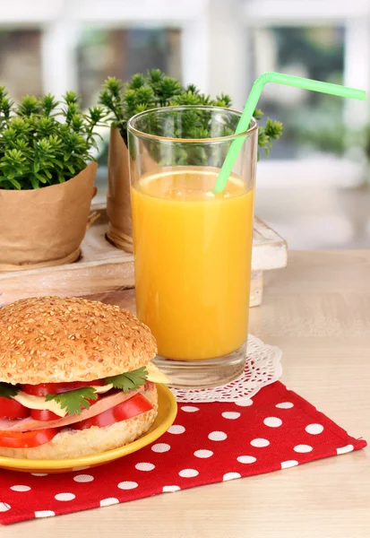 Appetizing sandwich on color plate on wooden table on window background — Stock Photo, Image