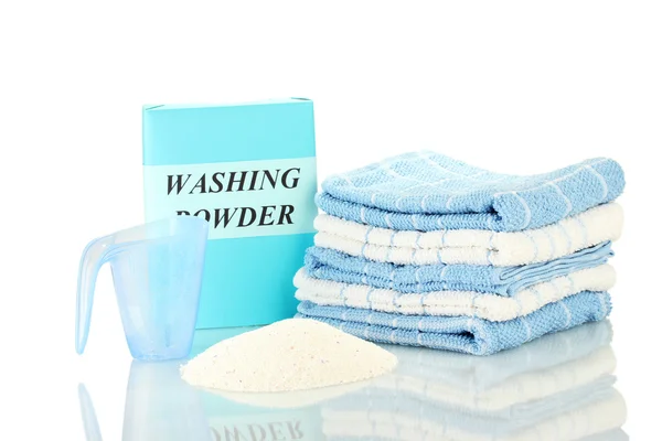 Box of washing powder with blue measuring cup and towels, isolated on white — Stock Photo, Image