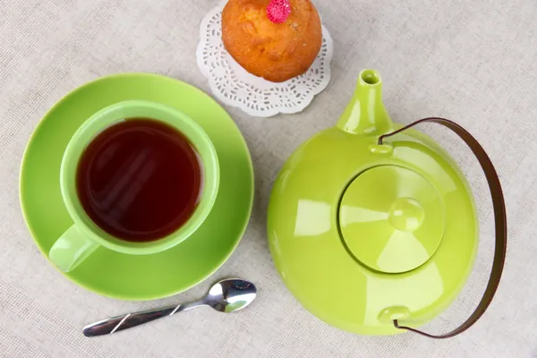 Top view of cup of tea and teapot on tablecloths — Stock Photo, Image