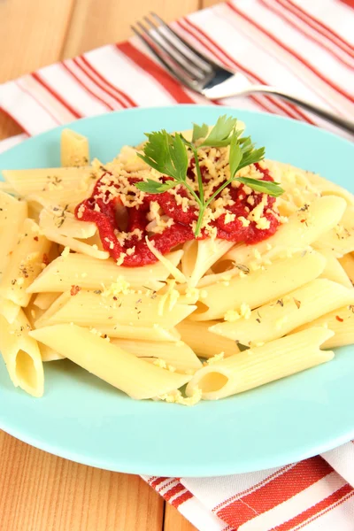 Rigatoni ahşap masa üstünde domates soslu makarna yemek yakın çekim — Stok fotoğraf