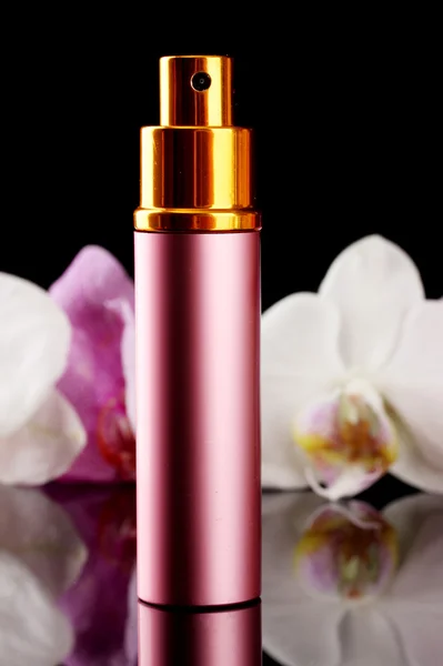 Dámské Parfémy v krásném láhev a květy orchidejí, na černém pozadí — Stock fotografie