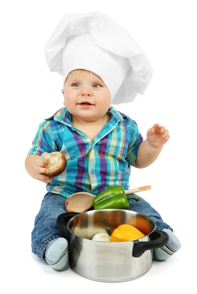 Menino de chapéu de chef com panela e legumes, isolado em branco — Fotografia de Stock