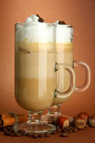 Café con leche fragante en vasos con especias, sobre fondo marrón — Foto de Stock
