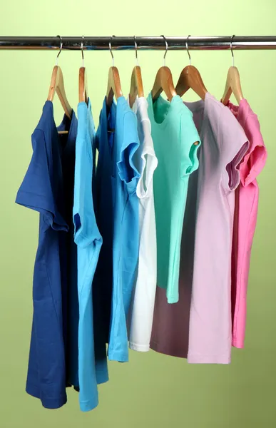 Variedade de camisas casuais em cabides de madeira, no fundo azul — Fotografia de Stock