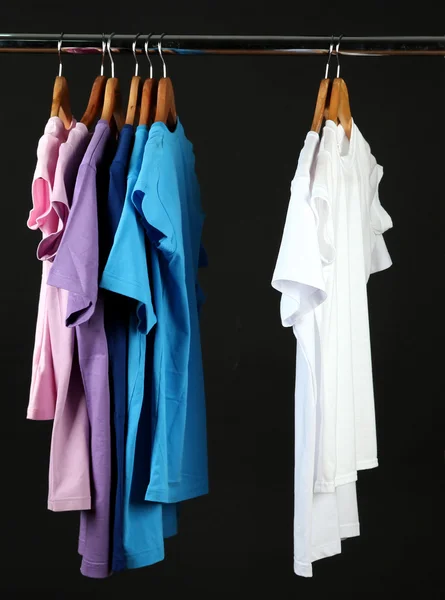 Variedade de camisas casuais em cabides de madeira, isolado em preto — Fotografia de Stock
