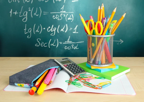 Zurück zur Schule - Tafel mit Bleistiftkasten und Schulutensilien auf dem Tisch — Stockfoto