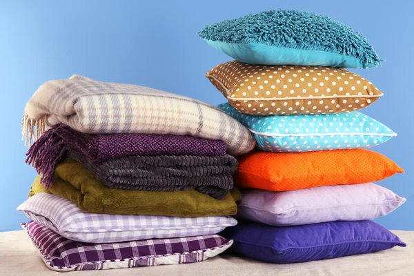 Hills colorful pillows and plaids on blue background — Stock Photo, Image
