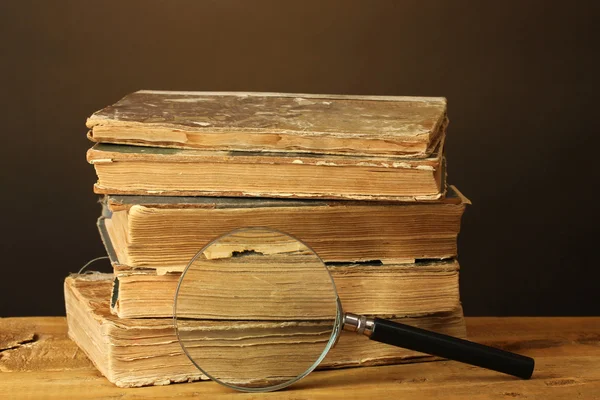 Magnifying glass and books on table — Stock Photo, Image