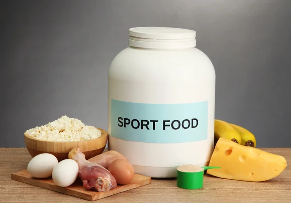 Burk proteinpulver och mat med protein, på grå bakgrund — Stockfoto