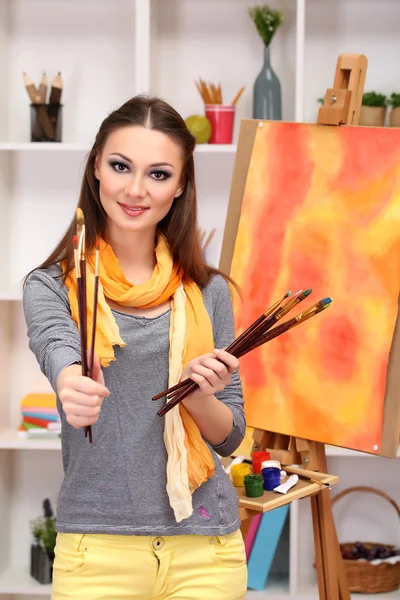 Mooie jonge vrouw schilder op het werk, op kamer interieur achtergrond — Stockfoto