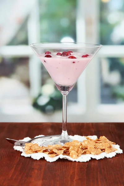 Glass of yoghurt dessert with berries, on bright background — Stock Photo, Image