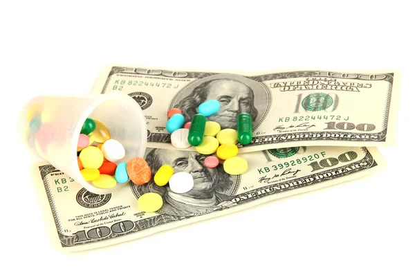 Pillen und Geld isoliert auf weiß — Stockfoto